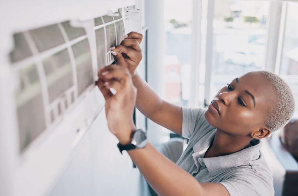 A professional performing a repair on an air conditioner on a wall of a North Fort Myers home.